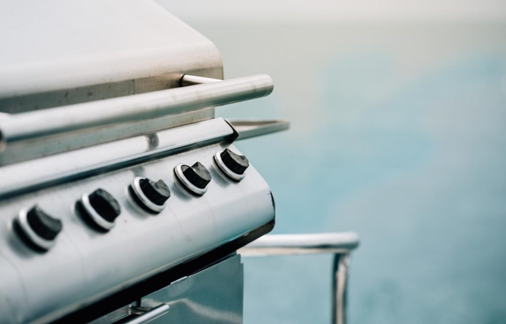 Vred och handtag på en gasolgrill i borstat rostfritt stål
